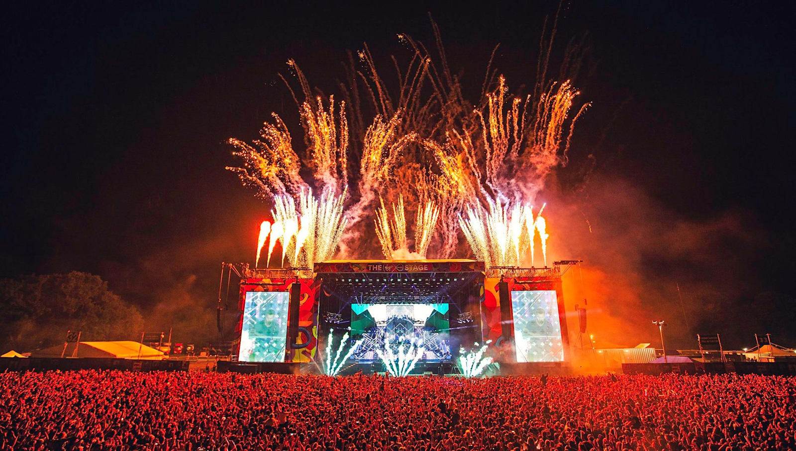 Festival main stage with fireworks above a large audience