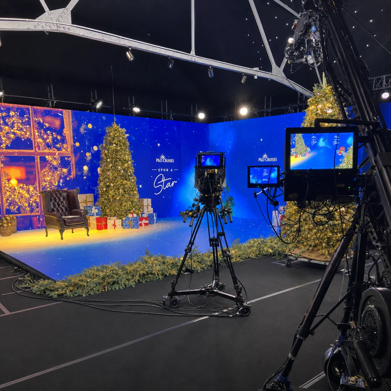 Broadcast cameras facing the illuminated Christmas Live studio set